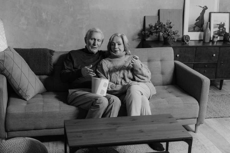 Older couple resting together on a sofa